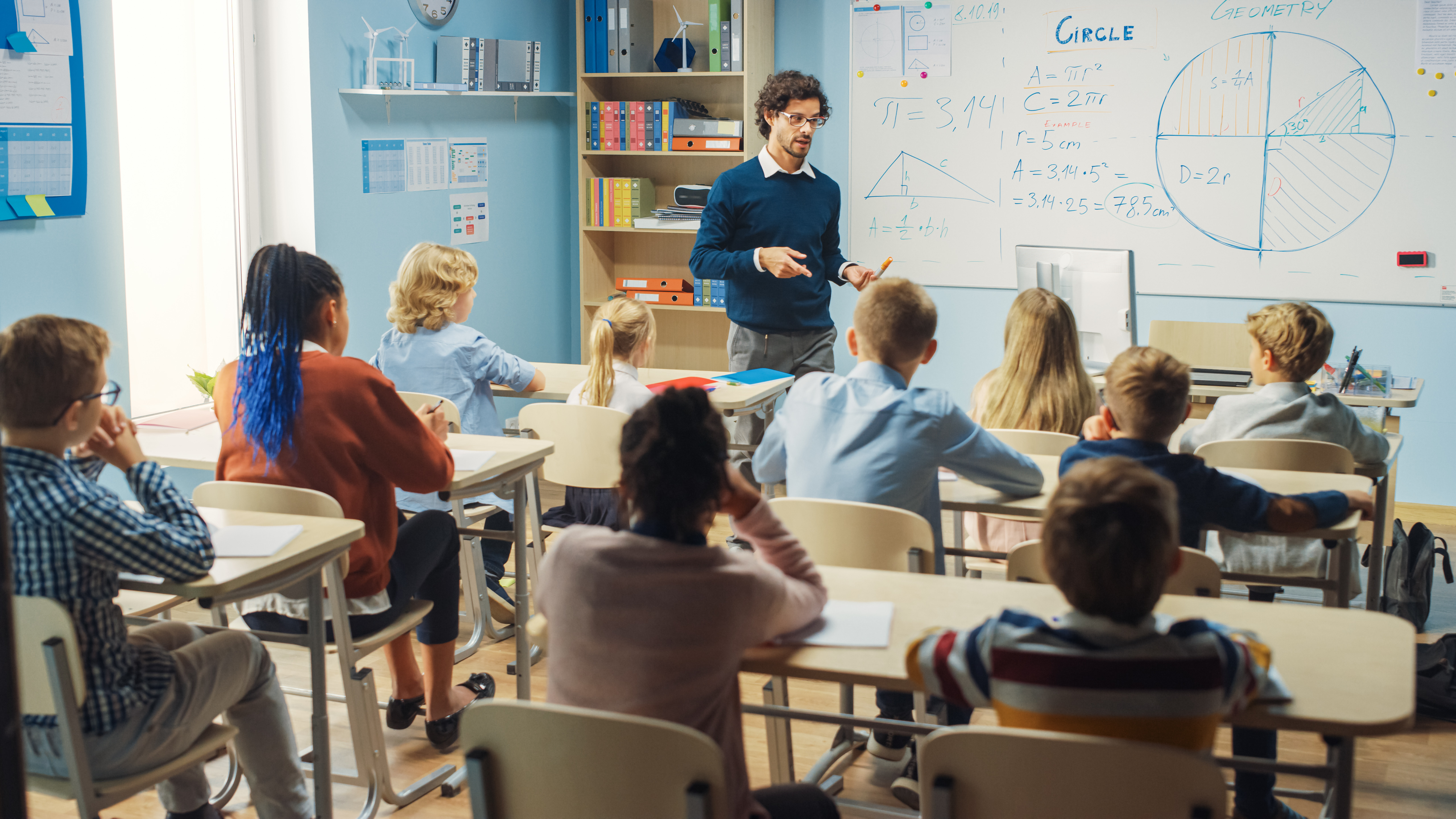 Elementary Classroom of Diverse Bright Children Listening Attentively to their Teacher Giving Lesson. Brilliant Young Kids in School Learning to Be Great Scientists, Doctors, Programmers, Astronauts