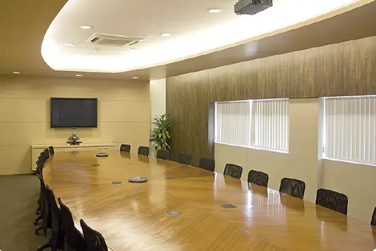 Large boardroom with a long wood conference table and presentation display.